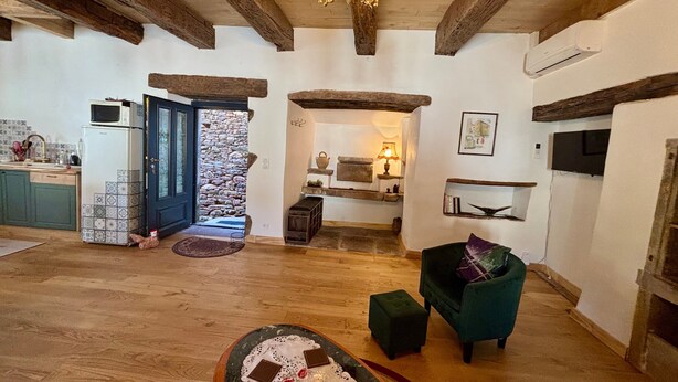 Uma sala ampla com lareira, uma mesa de jantar com velas e um espaço de estar aconchegante.