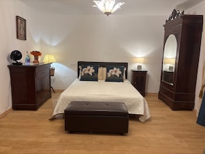 A bedroom with a bed, a dresser, a mirror, a fan, and a lamp. - Holiday Home 'Angelina' with Wi-Fi (Martrin)