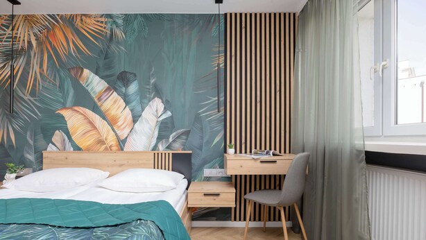 Un dormitorio con una cama, un escritorio y una silla.