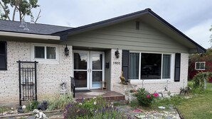 A house with a brick exterior, a front door with glass panels, and a small porch area.