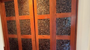 A wooden cabinet with multiple drawers and glass panels.