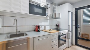 Eine moderne Küche mit Edelstahlgeräten, einer Mikrowelle und einer Kaffeemaschine.