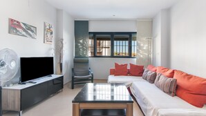 Ein Wohnzimmer mit Fernseher, Sofa und Couchtisch.