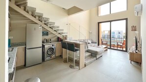 A modern apartment with a kitchen, dining area, and a balcony with a city view. - Xuru Stays I Eclectic 2 BDR Twin House @ Tawila El Gouna (El Gouna)