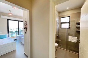 A modern bathroom with a glass shower enclosure, a white toilet, and a vanity with a towel hanging on the door. - Xuru Stays I Eclectic 2 BDR Twin House @ Tawila El Gouna (El Gouna)