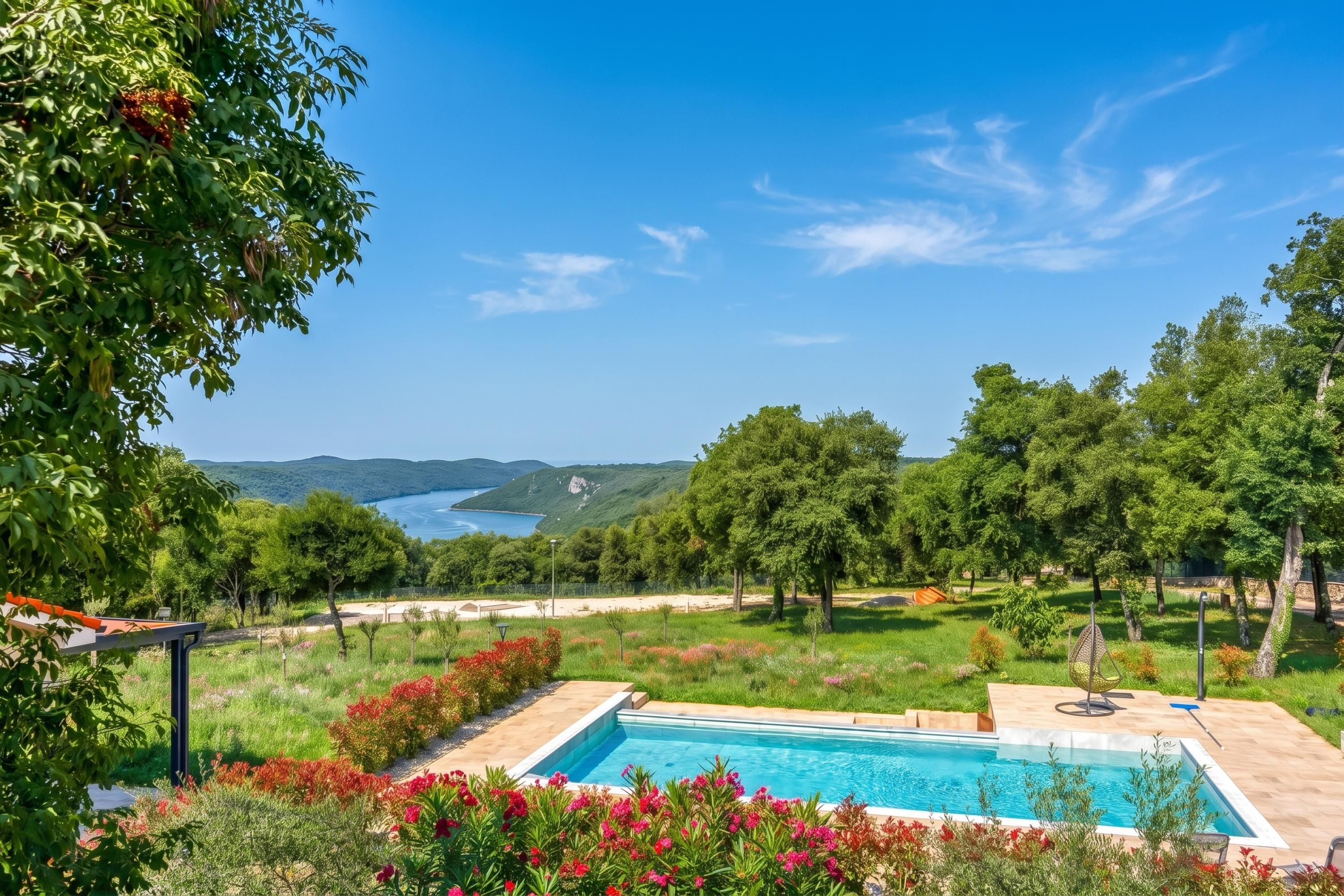 A pool area with a view of a lake and hills.