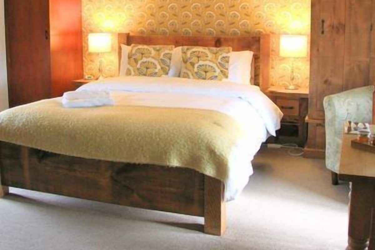 Una camera da letto con un letto in legno, carta da parati decorata e due lampade ai comodini.