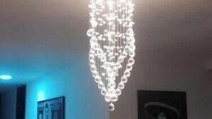 A room with a modern chandelier, a framed picture on the wall, and a chair in the foreground. - Boss-Level Hideout! (edificio calamary)
