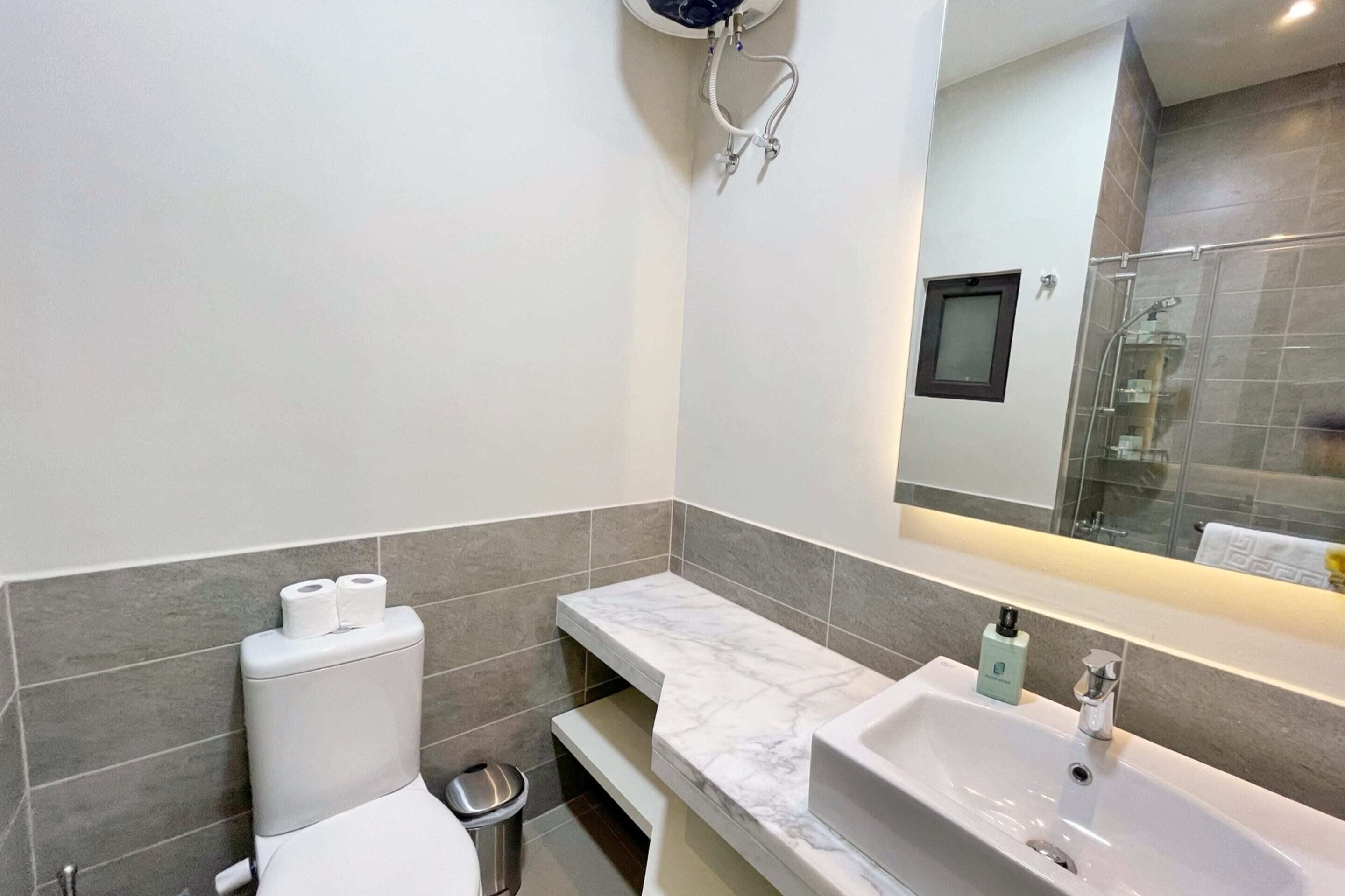 A modern bathroom with a toilet, sink, and shower area.