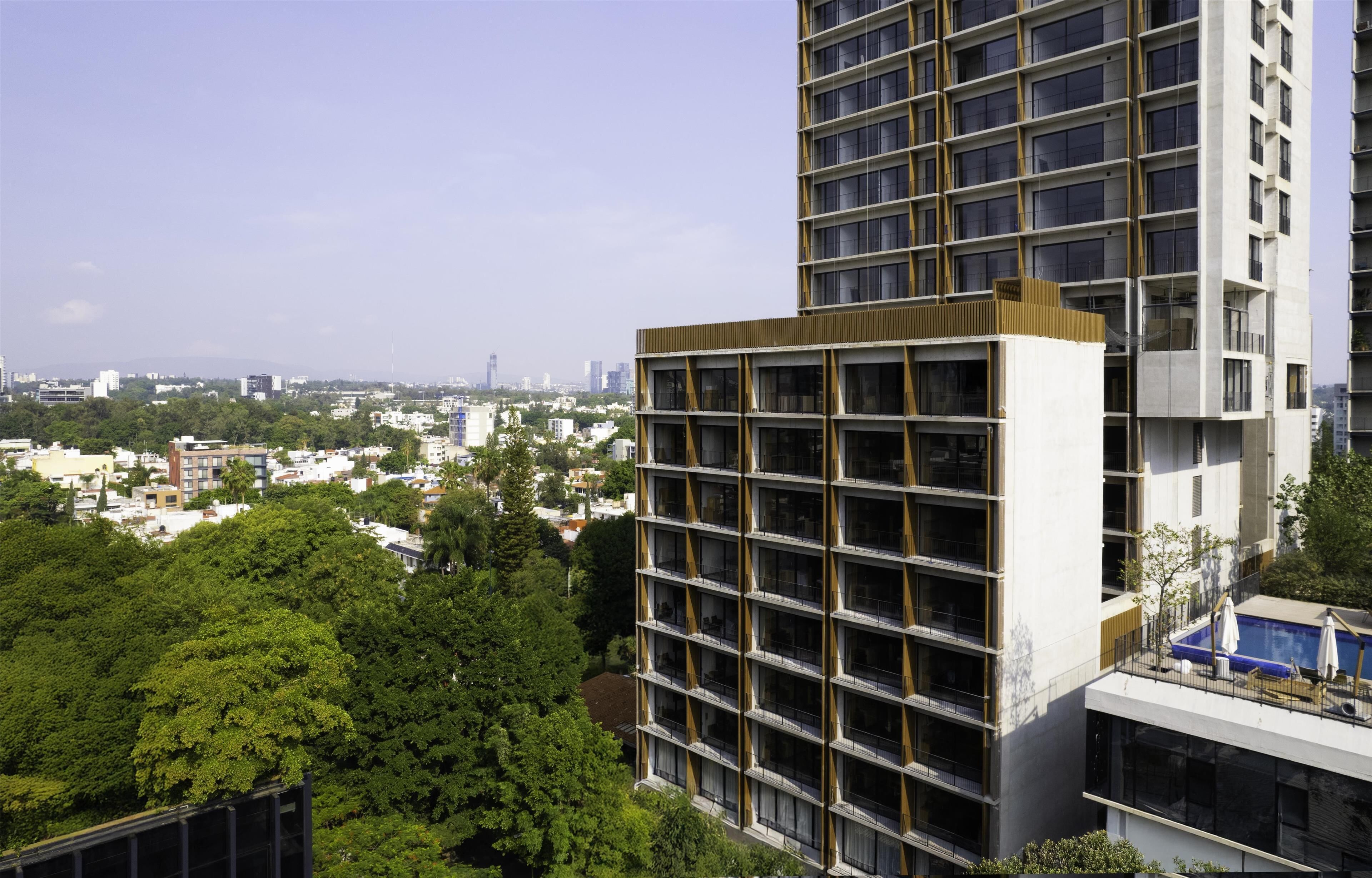Un immeuble de grande hauteur doté de nombreux balcons et d’une piscine sur le toit.