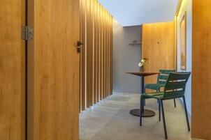 Un pasillo con paneles de madera, una mesa con sillas y un cartel con el número de habitación 101.