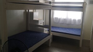 A bunk bed room with a window, a fan, and a small cabinet. - Studio Unit Around Recto U-belt (Manila)