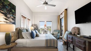 A bedroom with a bed, a TV, a desk, and a chair.