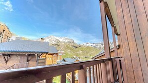 Un bâtiment en bois doté d’un balcon donnant sur un paysage montagneux.