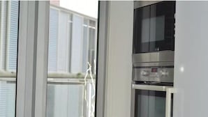 A modern kitchen with a stainless steel oven and a digital clock.