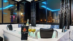 A modern bathroom with a bathtub, two wine glasses, and a bottle of champagne.