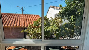 Un balcon avec un canapé, deux fauteuils et une table en verre.