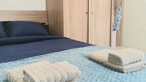 A bedroom with a bed, a wardrobe, and two towels on the bed.