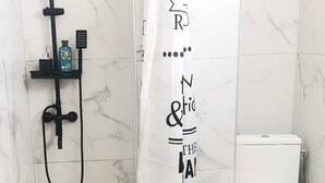 A bathroom with a shower, toilet, and a curtain with text.