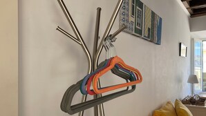 Un porte-manteau mural doté de plusieurs patères et orné d’un tableau représentant une maison.