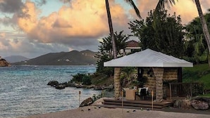 A coastal scene with a gazebo overlooking the sea, a rocky shoreline, and distant mountains. - Ritz-Carlton Club® / 2 Bed Lux Suite* (Fri to Fri) (East End)