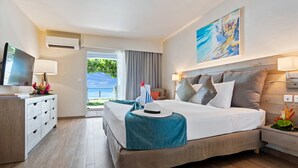 Habitación de hotel con cama, televisor, escritorio y vistas al exterior.