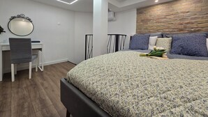 A modern bedroom with a wooden headboard, a desk with a chair, and a bed with floral bedding.