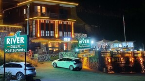 Un immeuble à plusieurs étages, doté d’une enseigne lumineuse indiquant « River Deluxe Restaurants ».