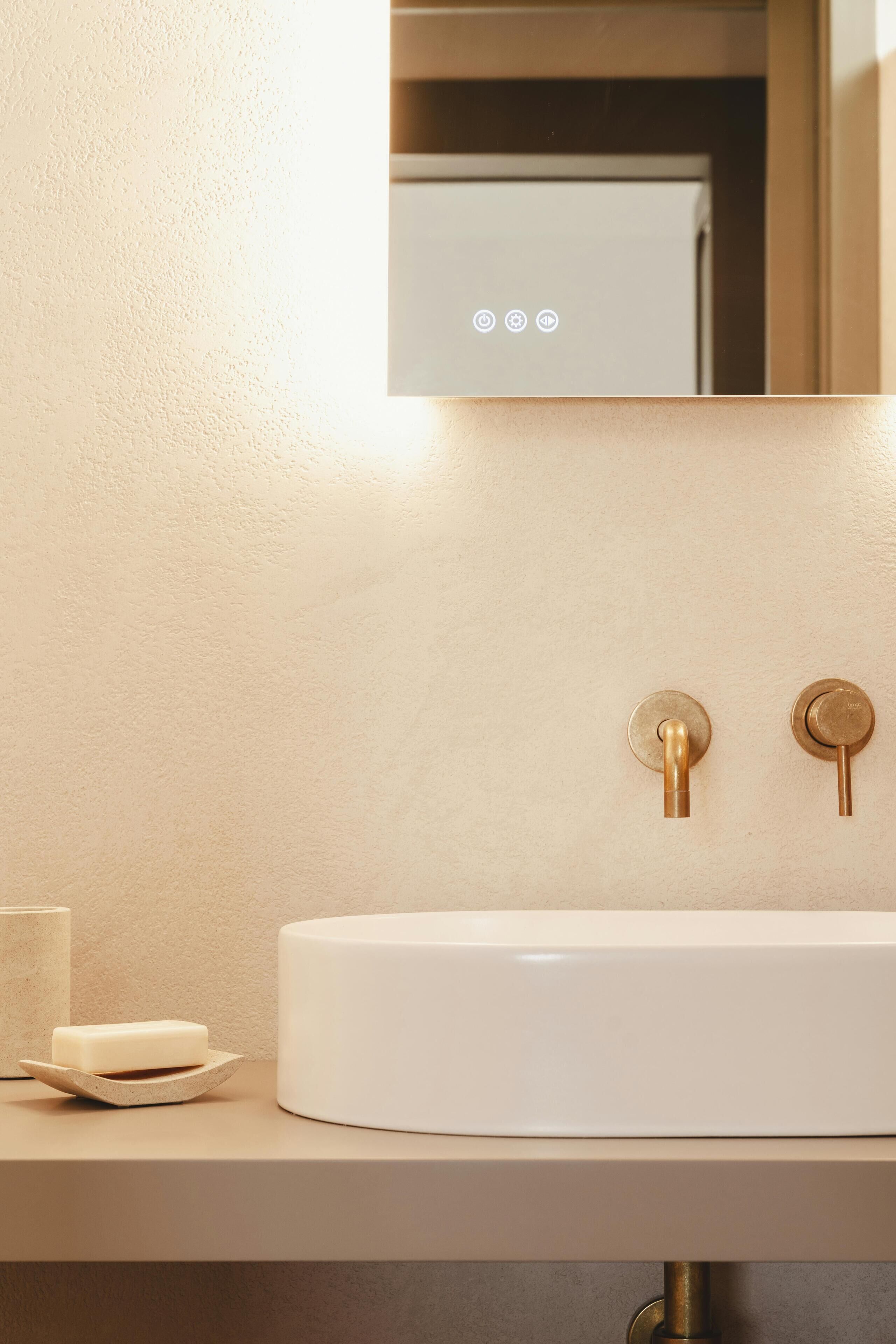 A bathroom with a white sink, a mirror, and a soap dish.