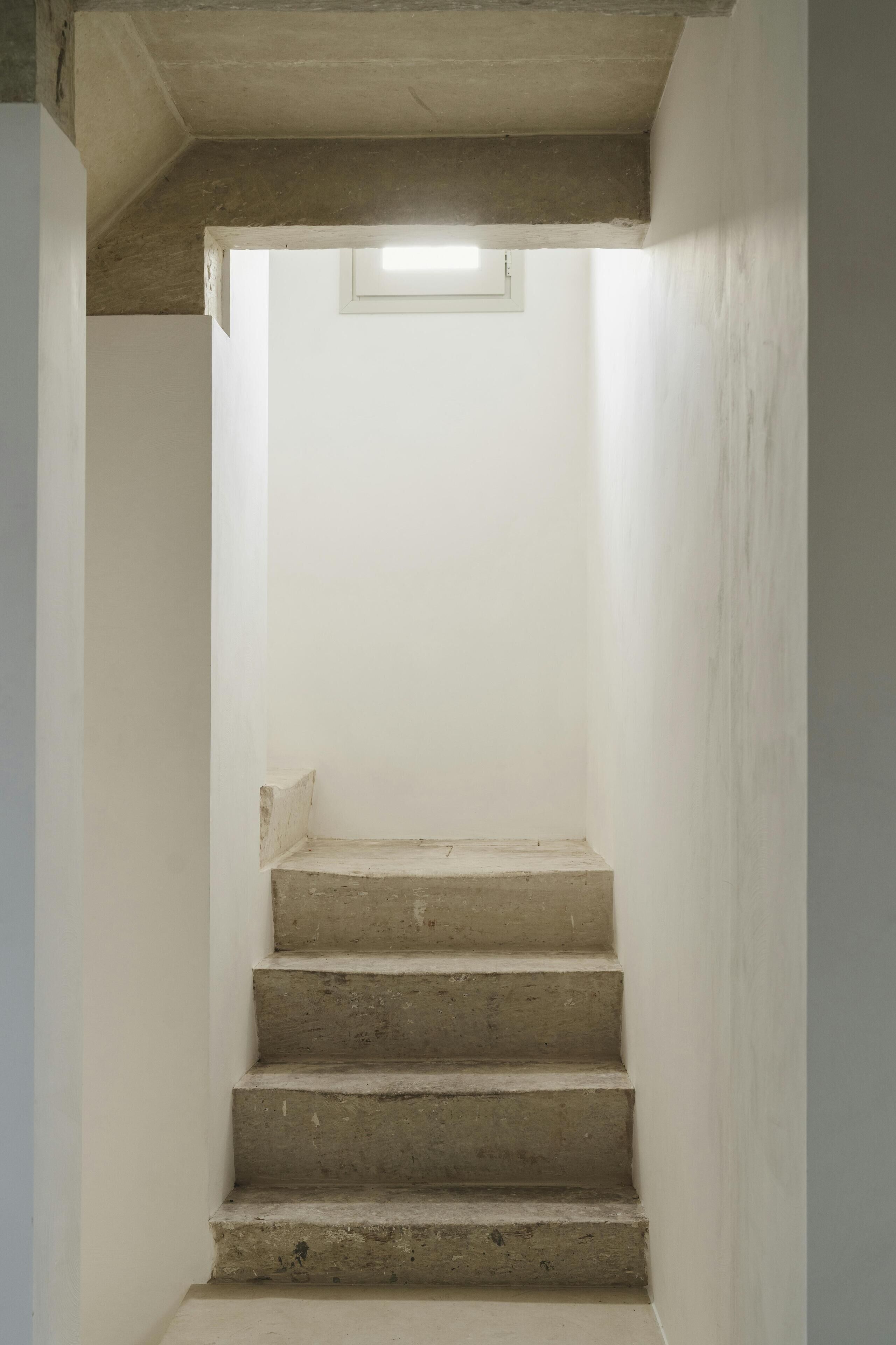 Una escalera de hormigón con un tragaluz en la parte superior.