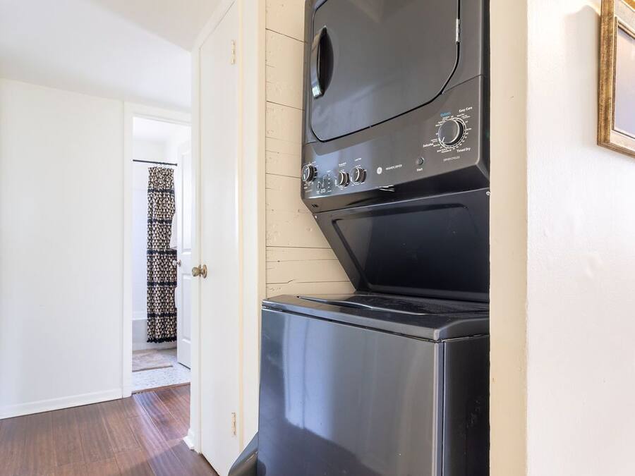 A compact kitchen with a built-in oven and microwave, a patterned tile floor, and a door leading to another room.