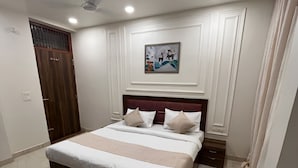 Ein Schlafzimmer mit einem Bett, einem Deckenventilator, einem gerahmten Bild und einem blauen Eimer.