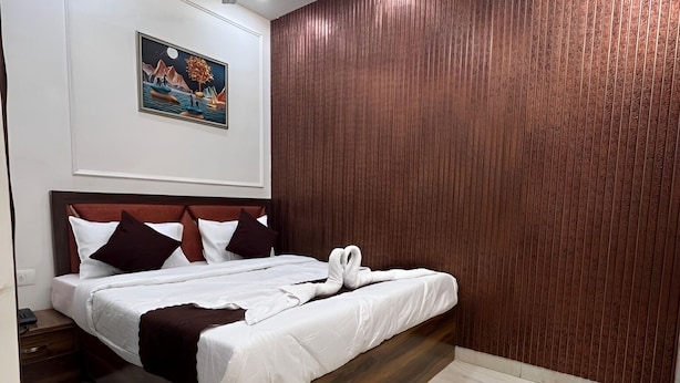 Ein modernes Schlafzimmer mit einem hölzernen Bettgestell, weißer Bettwäsche und einem Deckenventilator.