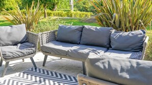 An outdoor seating area with wicker furniture and a patterned rug. - Charming 3-bedroom villa with heated pool and AC in Fronsac accross a river (Fronsac)