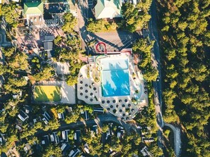 An aerial view of a residential area with a central swimming pool, surrounded by houses and greenery. - ZEcamping 4 étoiles familial 1km plage espace aquatique mobil-home 36m2 (Les Mathes)