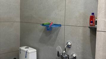 Un baño con inodoro, ducha y lavamanos.