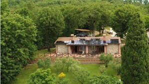 Una casa rústica de piedra, rodeada de exuberante vegetación y una valla de madera.