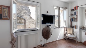 A room with a large window, a television mounted on the wall, a chair, and a radiator. - Montegrazie Holiday Home with Sea View, Private Terrace and Wi-Fi (Montegrazie)