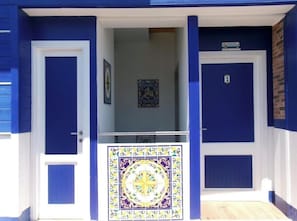 A blue building with two doors, one marked with the number 1, and a tiled entrance. - Marina Club (Giardini Naxos)