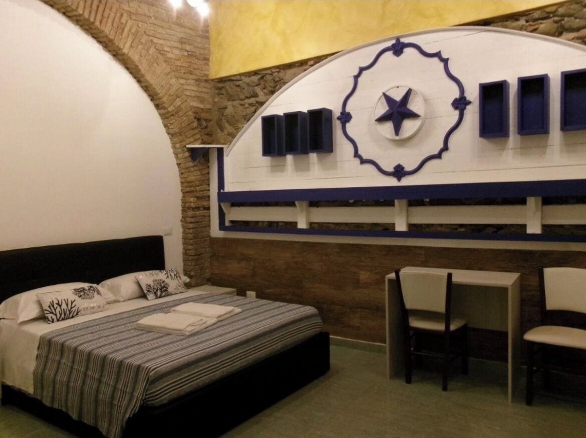 Un dormitorio con una cama, un escritorio y sillas.