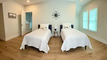Une chambre avec deux lits, une décoration murale représentant une boussole et une grande fenêtre.