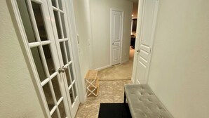 A hallway with a bench, a black mat, and a door with a window. - 4-bedroom house in welcoming Missouri City with WiFi, AC near NRG Stadium (Missouri City)