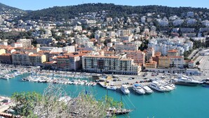 A marina with numerous boats docked, surrounded by a densely packed urban area with multi-story buildings.