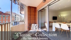 A modern apartment with a balcony, large sliding glass door, and a view of the cityscape.