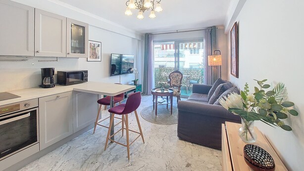 Une cuisine moderne avec un coin repas, un canapé et une vue sur le balcon extérieur.
