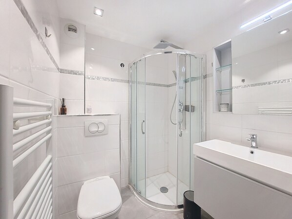 A modern bathroom with a glass-enclosed shower, a white toilet, and a vanity with a mirror. - N&J - FIORI SALEYA - Near Beach - Studio (Niza)