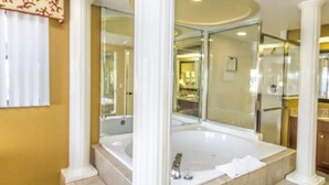 Ein Badezimmer mit einer großen Badewanne, einem Spiegel und einem Waschtisch.