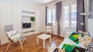 A modern living room with a TV, a small table, a chair, and a sofa. - N&J - SAVOY PROMENADE - Central - Near Beach (Niza)