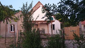 A house with a pitched roof, a visible door, and a small porch area.