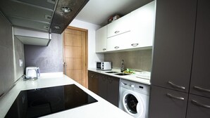 A modern kitchen with a built-in stove, microwave, sink, and washing machine. - Dream Villa in Cap Salou - Pool & Beach Paradise (Salou)